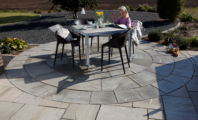 Smuk cirkelformet terrasse i sandsten bygogbolig
