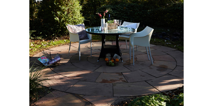 Smuk cirkelformet terrasse i sandsten bygogbolig